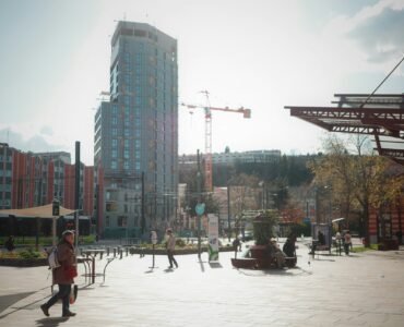 a group of people walking around a city square